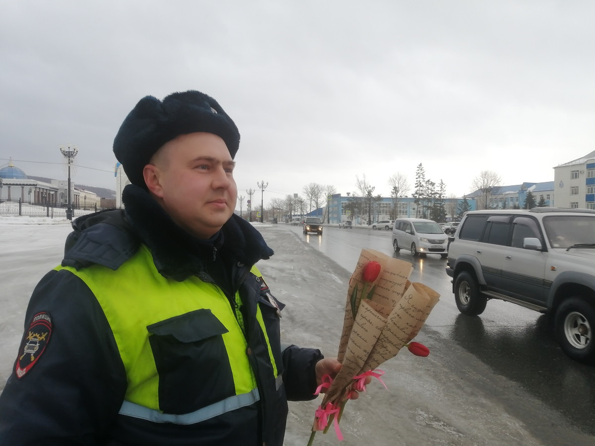 Сотрудники госавтоинспекции Сахалинской области дарят женщинам цветы.  Сахалин.Инфо