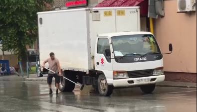 Водитель мыл грузовик под дождем во дворе дома в Южно-Сахалинске